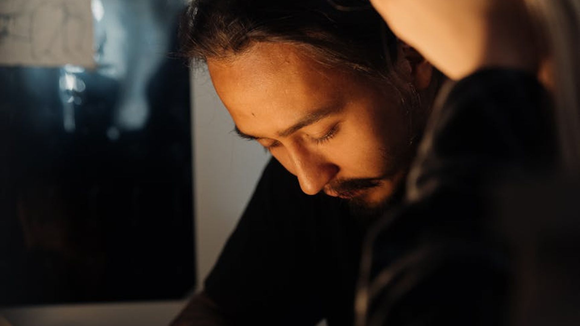 Man in a focused stance in a dimly lit, minimalist gym environment.
